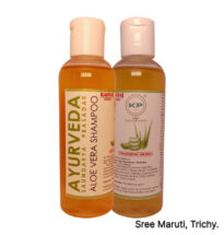 Bottle of Aloe Vera shampoo with aloe vera leaves in background.