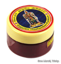 Gopuram Thazhamboo Kumkum container with red fragrant kumkum powder and flowers.
