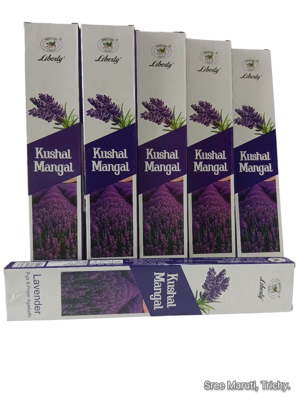 Burning lavender incense stick with lavender flowers in the background.