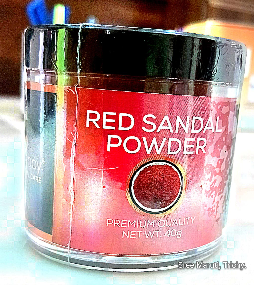 Red Sandalwood powder in a bowl with sandalwood sticks beside it.