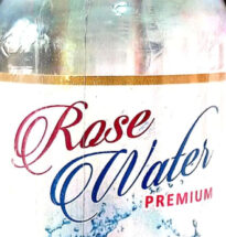 Bottle of Rose Water Premium with rose petals and water bowl.