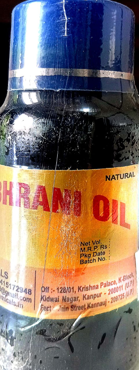 Bottle of Naresh Chemicals Sambhrani Oil with resin and diya lamp.