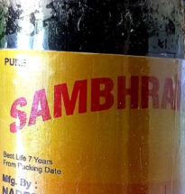 Bottle of Naresh Chemicals Sambhrani Oil with resin and diya lamp.