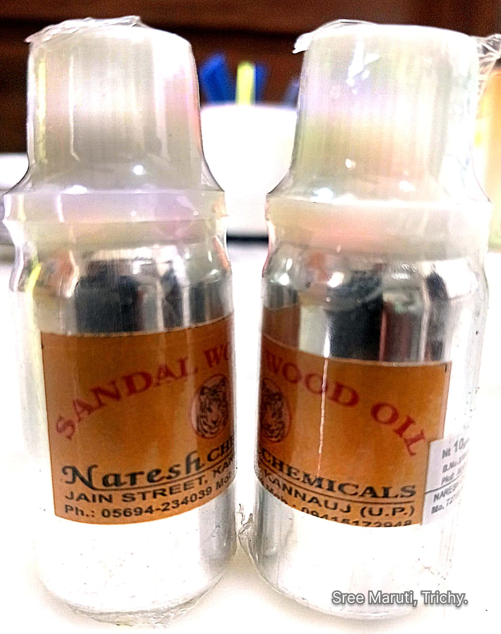 Bottle of sandalwood oil with sandalwood sticks and powder.
