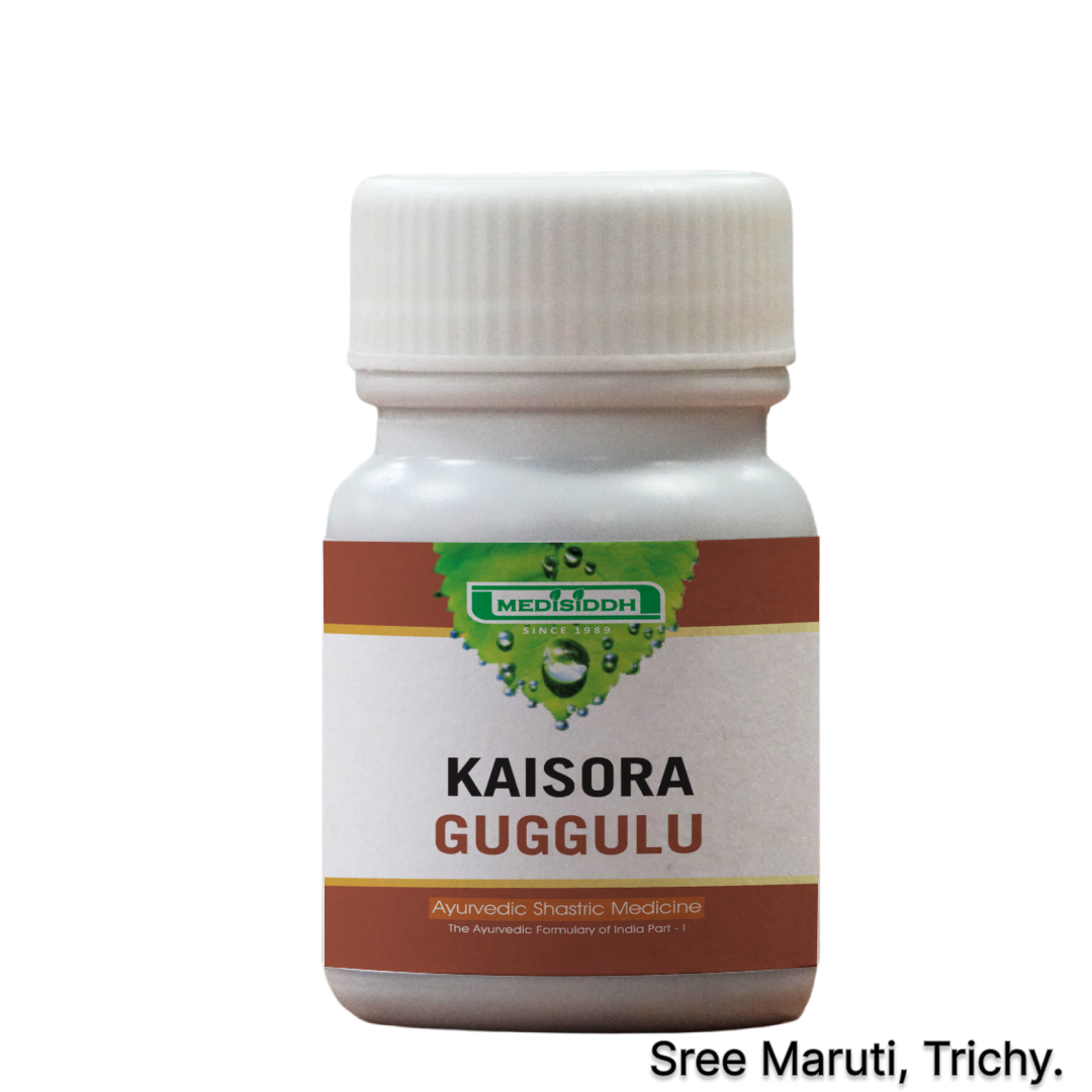 Kaisora Guggulu tablets with Ayurvedic herbs on wooden surface