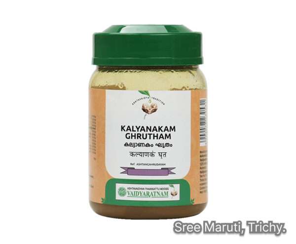 Ayurvedic medicated ghee Kalyanakam Ghrutham in a brass bowl with herbs around it.