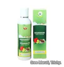 Bottle of Kesaranjini Kera Thailam with coconut and saffron strands, representing Ayurvedic hair oil.