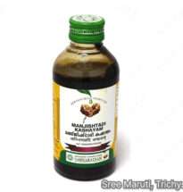 Bottle of Manjishtadi Kashayam with Manjishta roots and herbal powders.